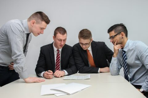 Business team reviewing project documents and financial reports during a contract revenue close review