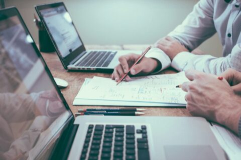 Finance professionals reviewing financial reports and supporting documents during an audit and control review