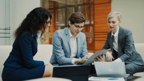 Finance professionals discussing business records in a meeting, illustrating corporate bank-account governance and treasury controls.