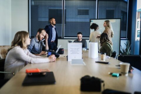 Business colleagues seated around a table reviewing documents and discussing customer rebate and sales incentive arrangements