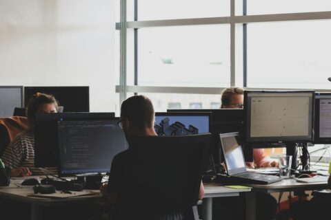 Finance and technology colleagues reviewing data on a computer during a system migration project