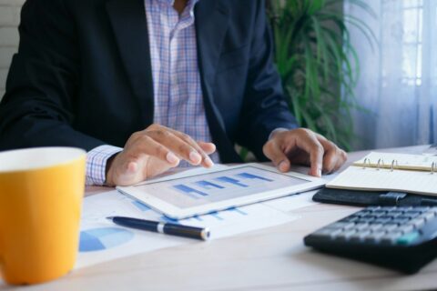 Finance professional reviewing data on a tablet during a financial planning discussion