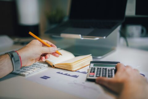 Financial documents and calculator arranged on a desk for financial reporting review