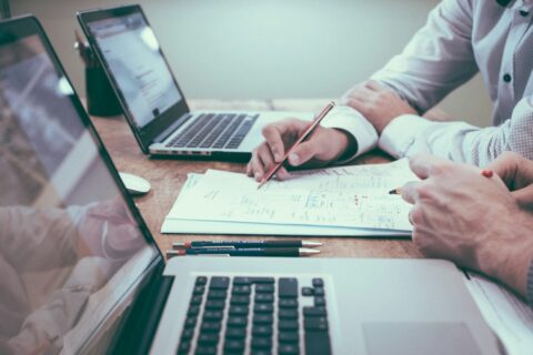 Finance professionals reviewing spreadsheets and financial reports at a desk